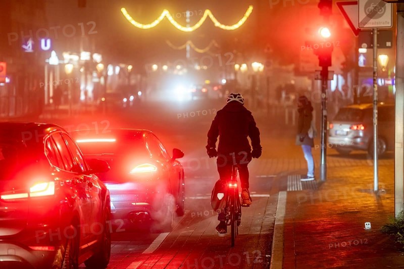 Cyclist, darkness, inner city traffic, Rüttenscheider Straße, bicycle lane, fog, autumn, winter, evening traffic, North Rhine-Westphalia, Germany, Europe