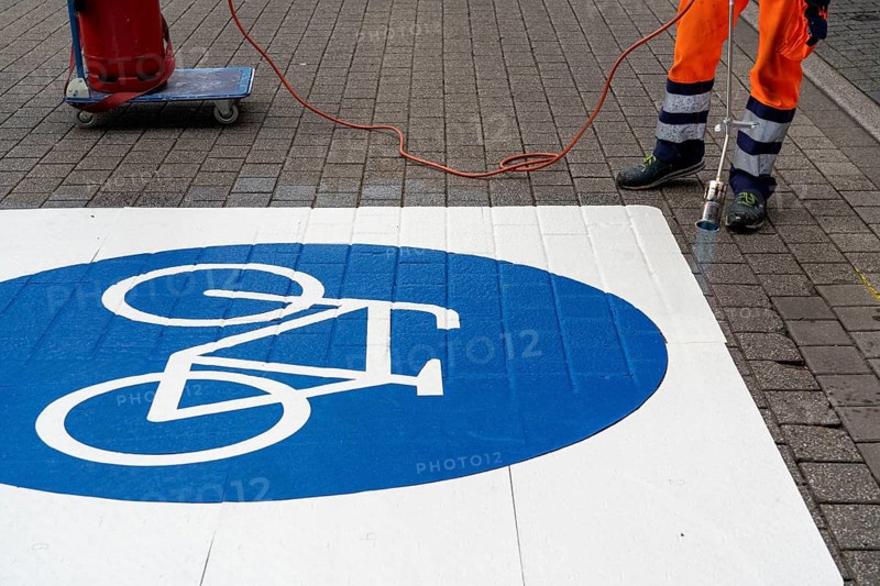 Application of road markings for a cycle lane, Rüttenscheider Straße in Essen, in the shopping and gastronomy district, cyclists have right of way over motorised vehicles, part of a cycle axis through Essen's city centre
