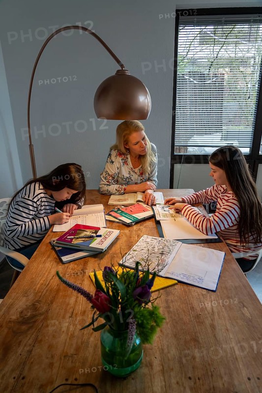 Homeschooling, during the lockdown in January 2021, mother helps her two daughters, at home, learning, school closures, distance learning, effects of the corona crisis in Germany