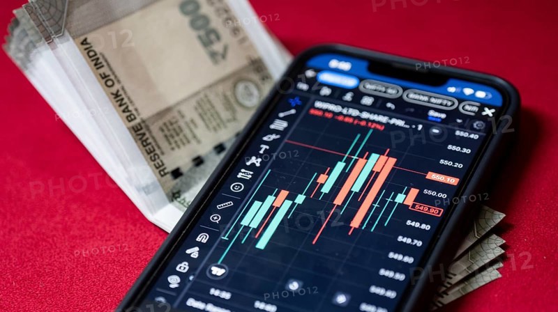 Stock market graph or chart display on a mobile phone against Indian 500 rupee paper currency note