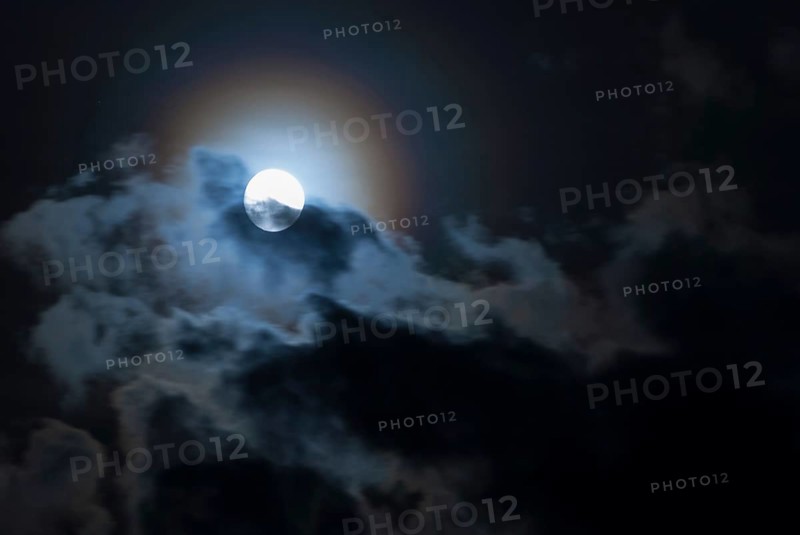 The full moon shines brightly in a cloudy, stormy, black sky and has a halo in rainbow colours (corona, halo), fairytale-like, mystical night shot, dark, somewhat creepy mood, ghostly, symbolic image for fear, nightmare, horror, fantasy, motion blur, wipe effect, Mecklenburg-Western Pomerania, Germany, Europe