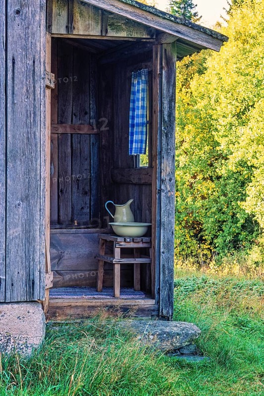 Old wooden outhouse with a sink and a jug at an old cottage in the countryside, Sweden, Europe
