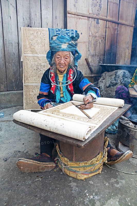 Vietnamese woman from the Hmong minority draws a pattern on linen fabric, Lung Tam linen weaving mill, Ha Giang province, Vietnam, Asia