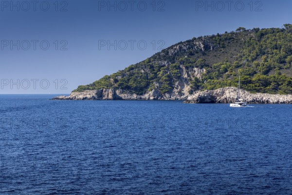 Blue sea and green hills with a sailing boat under a clear sky, Lastovo, Neretva, Croatia, Europe
