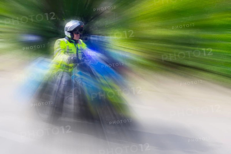 Policeman on a motorbike driving fast along the road, the speed is emphasised by the motion blur, Stuttgart, Baden-Württemberg, Germany, Europe
