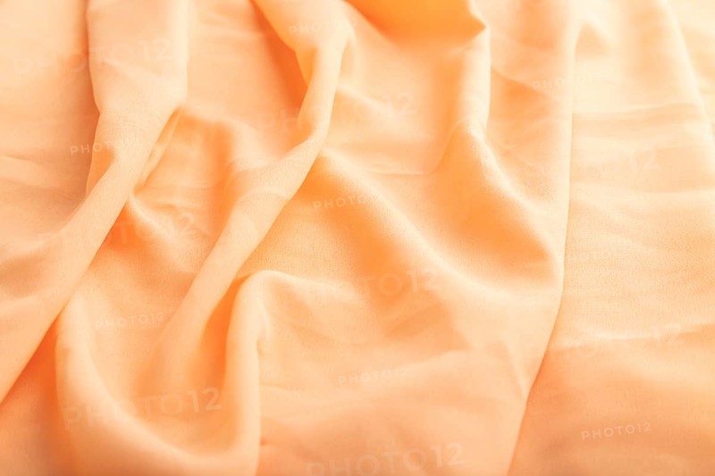 Fragment of orange linen tissue. Side view, natural textile background and texture. wave concept, abstract