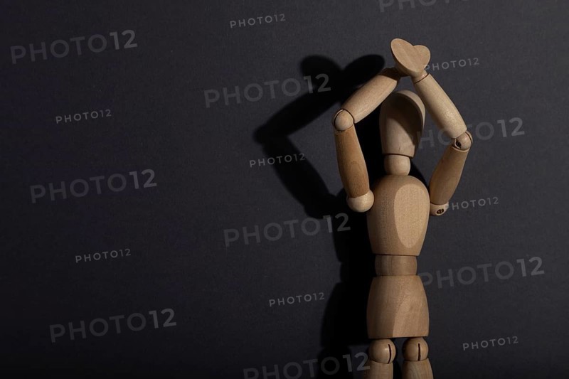 Wooden mannequin stands with raised hands on gray background. protest, attention concept. copy space, hard light
