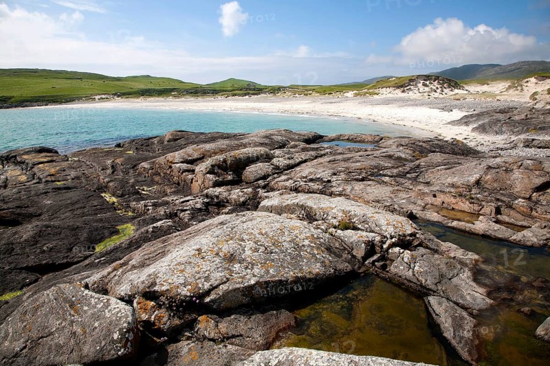 Rocky headland and sandy beach at Bagh a Deas, South Bay, Vatersay island, Barra, Outer Hebrides, Scotland, UK