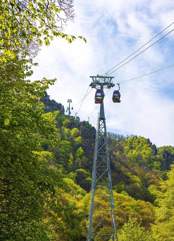 Cable car or gondola lift over a wooded mountain slope with cabins or gondolas and cable car supports or stands or girders, Erlebniswelt Thale, view up to the Hexentanzplatz, freshly leafy trees in spring, spring, Saxony-Anhalt, Germany, Europe