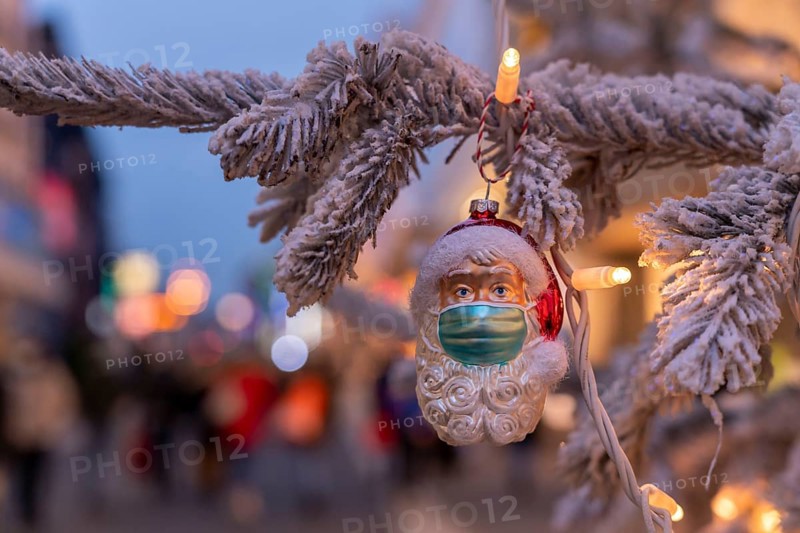 Symbolic picture Christmas in the Corona crisis, Father Christmas figure, Christmas tree decoration, with mouth-nose mask, everyday mask, in a pedestrian zone, shopping street