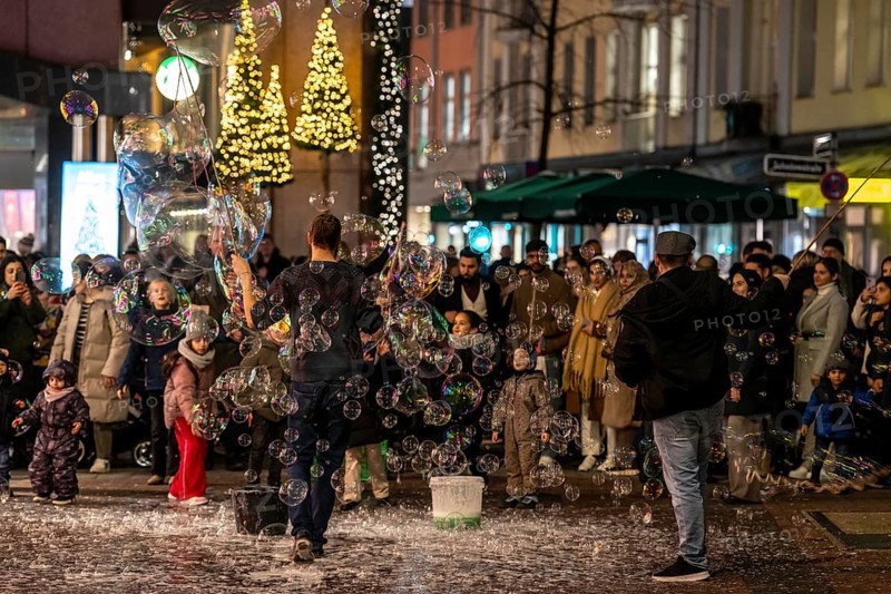 Pre-Christmas season, street artists, creating large soap bubbles, at Schadow-arcades, in the city centre of Düsseldorf, North Rhine-Westphalia, Germany, jeweller, Wempe, Europe