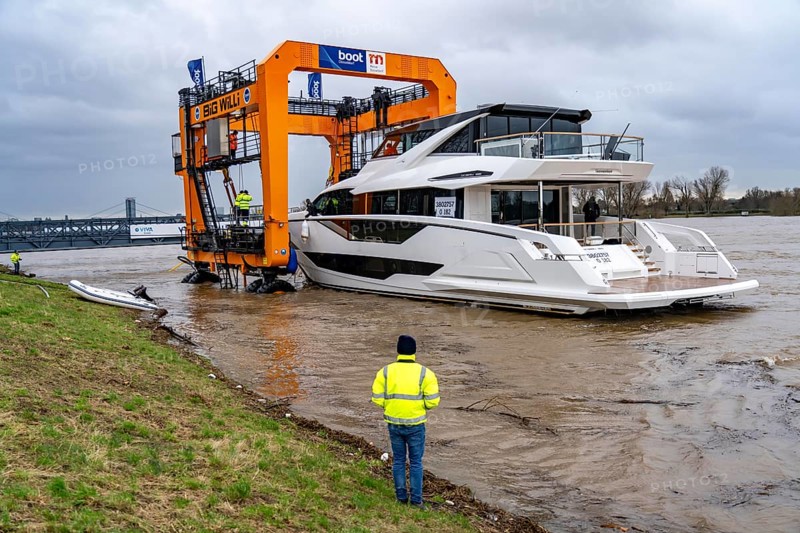 Craning the €6.3 million Sunseeker 88Y motor yacht, weighing 82 tonnes, in preparation for the world's largest water sports trade fair, Boot in Düsseldorf, luxury yachts are driven across the Rhine to the trade fair and brought ashore with the help of the Big Willi ship crane and transported to the exhibition halls on a low-loader, North Rhine-Westphalia, Germany, Europe