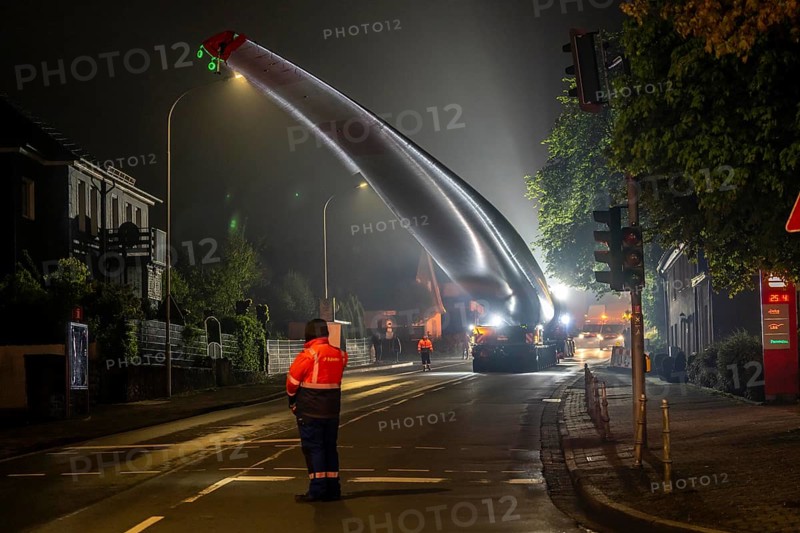 Transport of a 68 metre long, 22 tonne blade of a wind turbine, here in Breckerfeld, with a self-propelled Blade-Lifter vehicle, over a 40 km long route, over 2 nights, in the Bergisches Land, through towns, villages, over country roads, narrow through roads, to the construction site of the wind turbine near Hagen, North Rhine-Westphalia, Germany, Europe