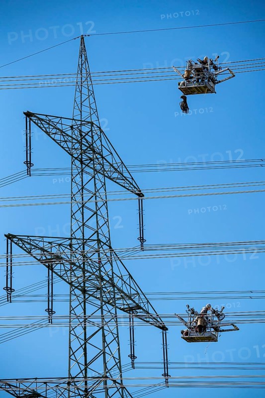 Construction of a new line route, 380 KV extra-high-voltage line between Osterath and Gohr, near Neuss, fitters in line trolleys, on the conductor cables, installing field spacers at great heights, North Rhine-Westphalia, Germany, Europe