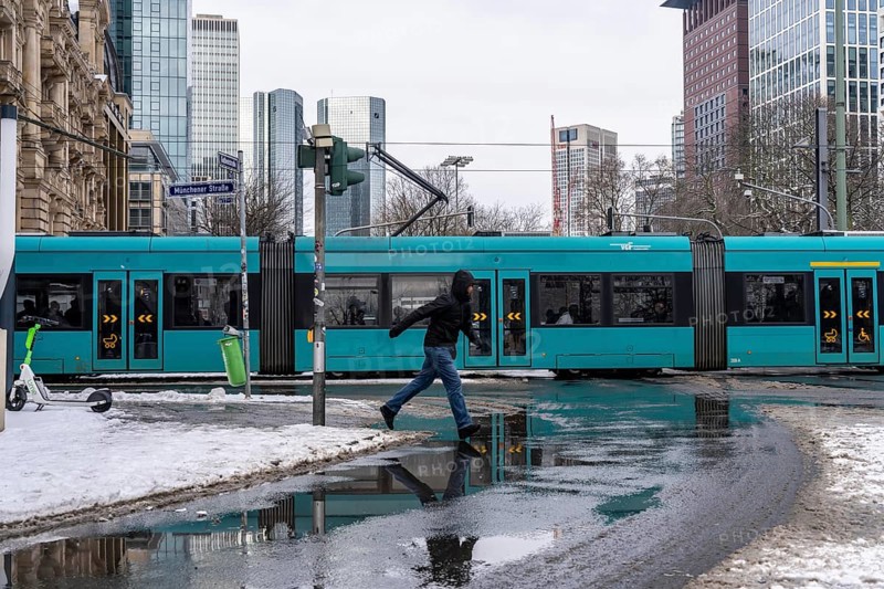 Winter in the city, Gallusanlage street, puddles, pools of water, melt water, pedestrians, Frankfurt, Hesse, Germany, Europe