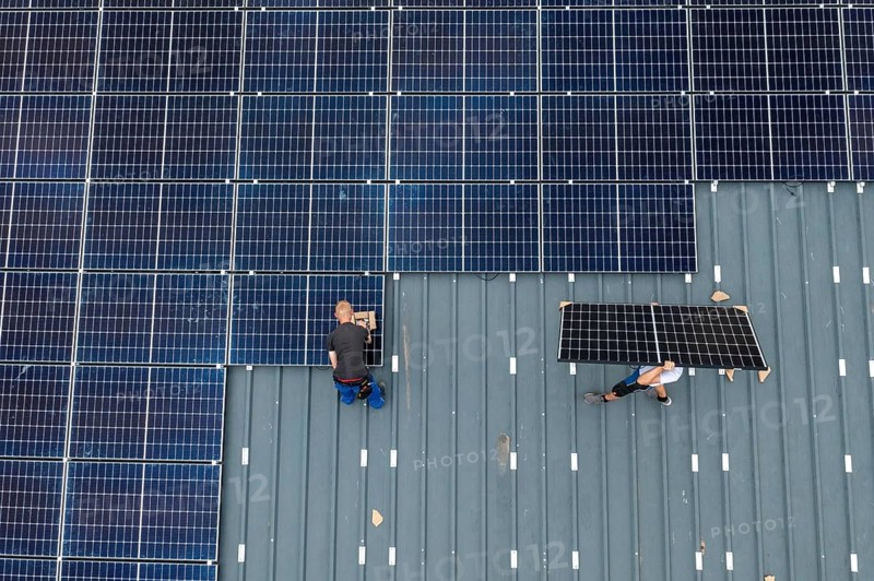 Installation of solar modules on the roof of a barn on a farm, over 210 photovoltaic modules are installed on the roof, North Rhine-Westphalia, Germany, Europe