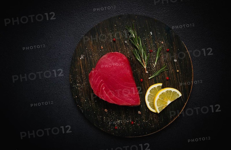 Fresh red tuna fillet, for steak, raw, top view, on a black plate, no people