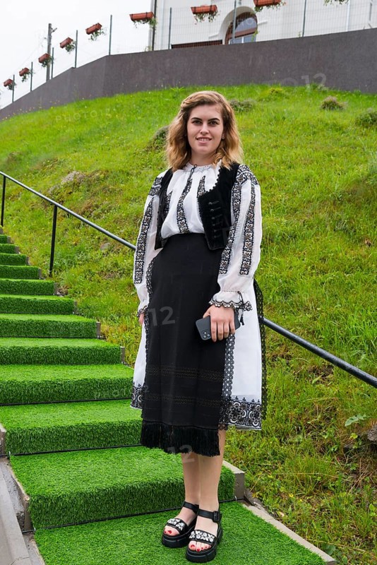 Young woman in traditional dress standing on a green staircase, woman in traditional traditional costume, Vadu Motilor, Alba, Transylvania, Romania, Europe