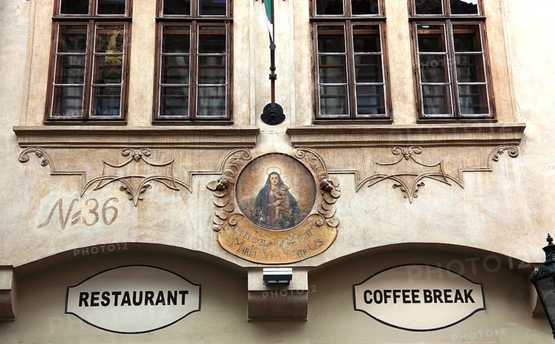 Old historic façade with image of the Virgin Mary and signs for restaurant and coffee break in the Lesser Town district of Prague, Prague, Czech Republic, Europe