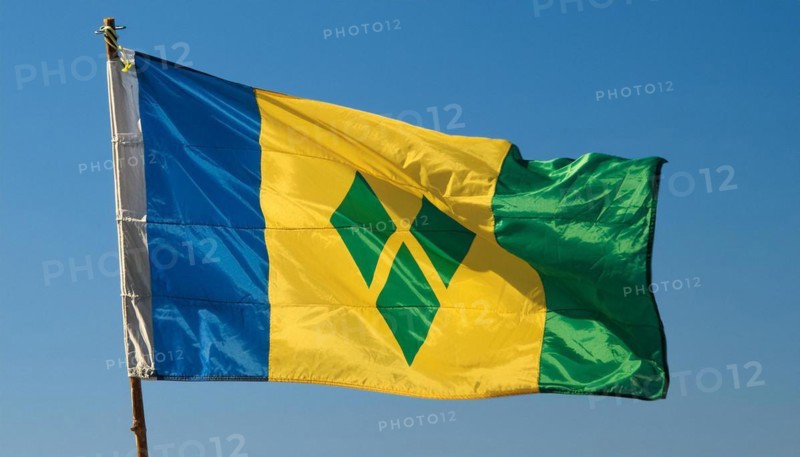 The flag of the Grenadines flutters in the wind, isolated against a blue sky