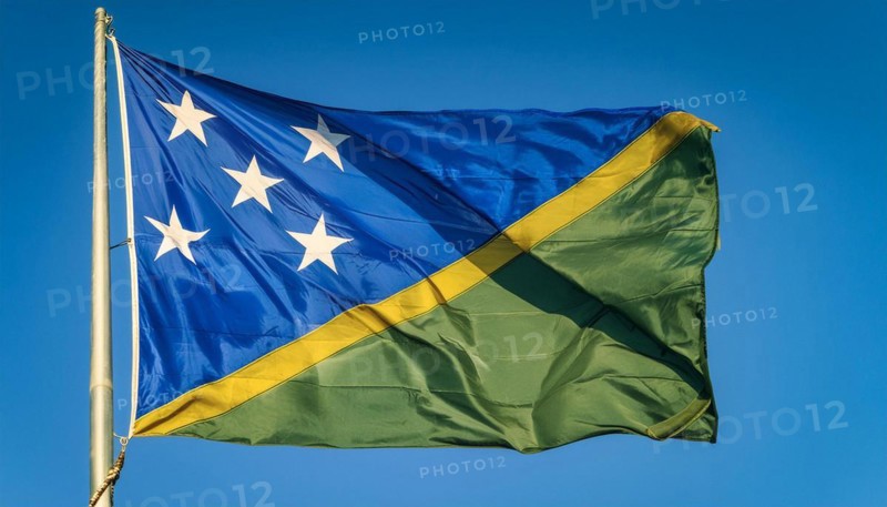 The flag of Solomon Islands, Solomon Islands, island nation in the South Seas, flutters in the wind, isolated against a blue sky, Oceania