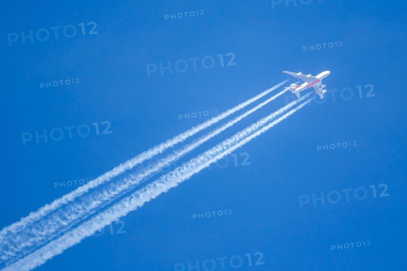 An Emirates Airbus A380-800 aircraft with registration number A6-EVN in flight with contrails over Munich Airport, Germany, Europe