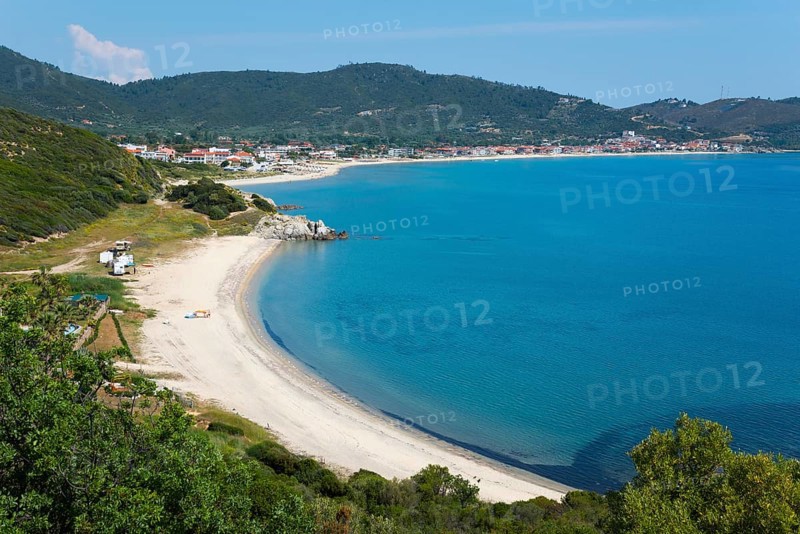 View of a quiet coastal landscape with beach and azure blue sea, surrounded by hills and small buildings, Sarti, Sithonia, Chalkidiki, Halkidiki, Central Macedonia, Greece, Europe