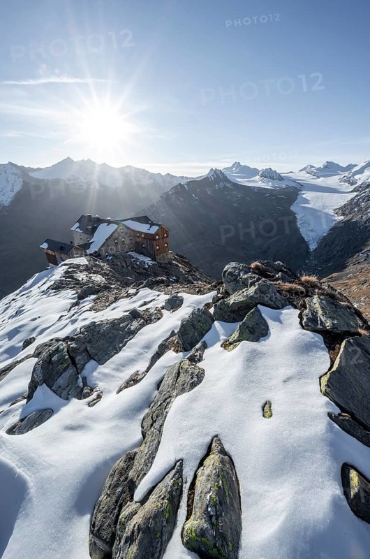 Mountain panorama and glacier, mountain hut Ramolhaus in autumn with snow, view of Gurgler Ferner with summit Hochwilde and Falschungsspitze, at sunrise with sun star, Ötztal Alps, Tyrol, Austria, Europe