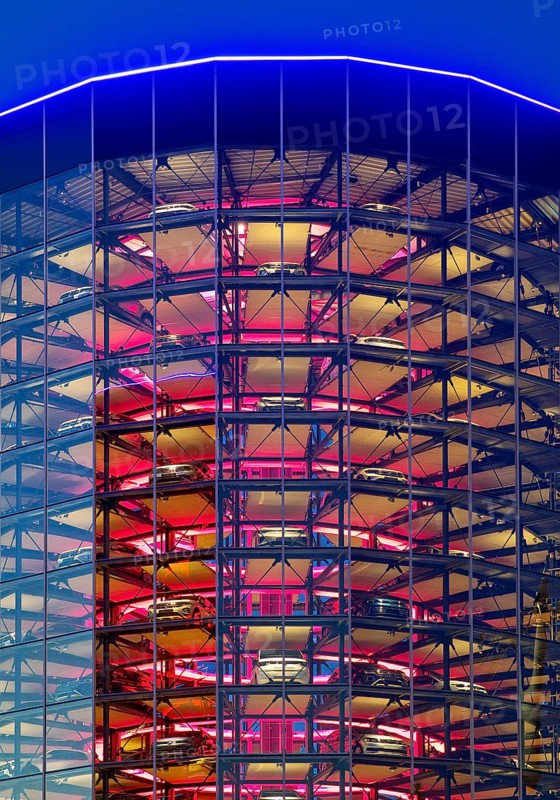 An illuminated car tower with new cars for delivery in the evening, Autostadt, Volkswagen AG, Wolfsburg, Lower Saxony, Germany, Europe
