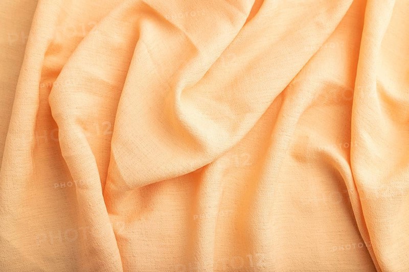 Fragment of orange linen tissue. Top view, natural textile background and texture. wave concept, abstract
