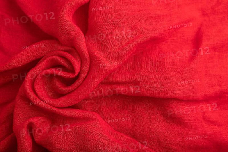 Fragment of red silk tissue. Top view, flat lay, natural textile background and texture. wave concept, abstract, spiral form