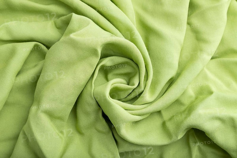 Fragment of green linen tissue. Side view, natural textile background and texture. wave concept, abstract, spiral form