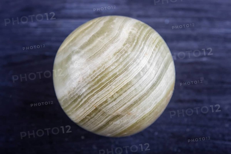 Green onyx sphere on a black background, close up