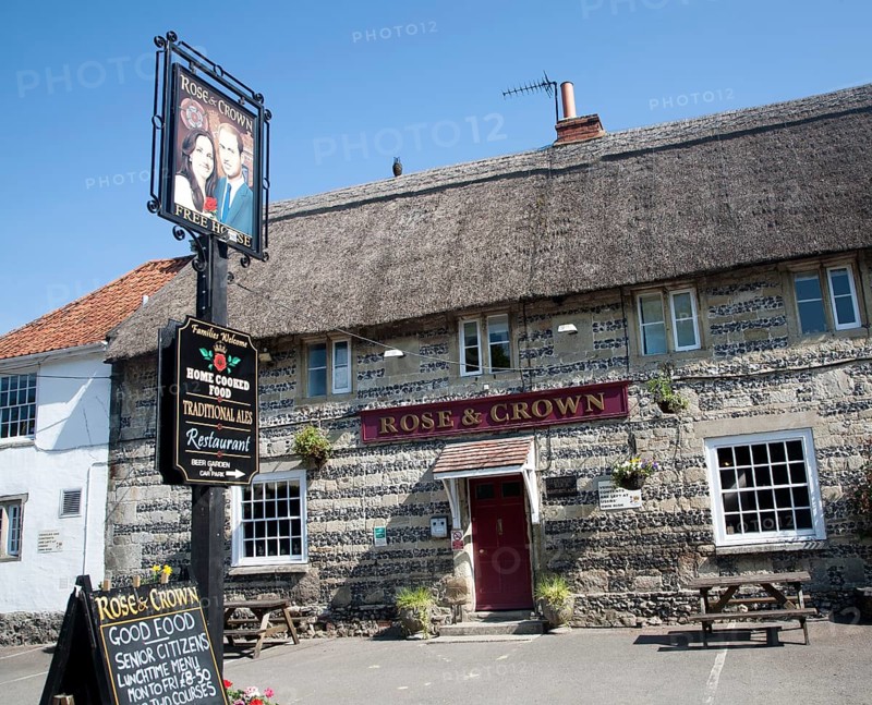 Rose and Crown pub at Tilshead, Wiltshire, England with pub sign painted of Prince William and his wife Kate Middleton