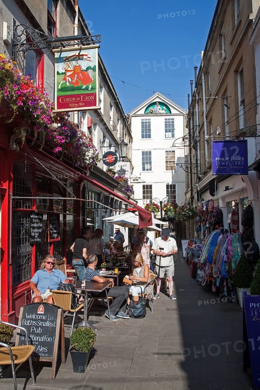 People enjoying summer sunshine and drink outside the Couer de Lion pub, Northumberland Passage, Bath, Somerset, England, United Kingdom, Europe