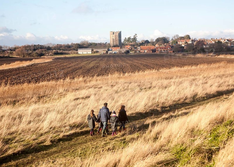 Family walking by the village and castle looking across fields, Orford, Suffolk, England, United Kingdom, Europe