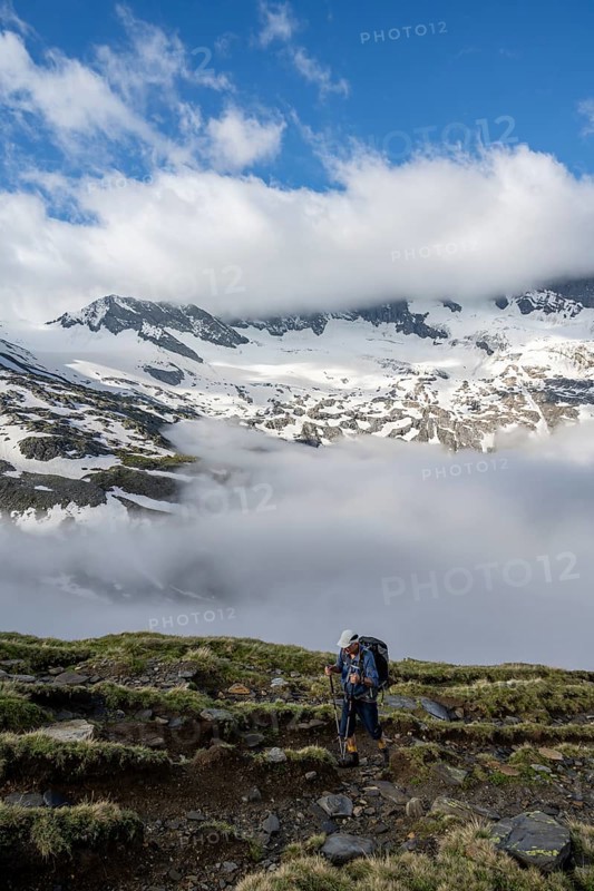 Mountaineers on a hiking trail, high fog in the valley, glaciated mountains with Schlegeiskees above the clouds, Berliner Höhenweg, Zillertal Alps, Tyrol, Austria, Europe