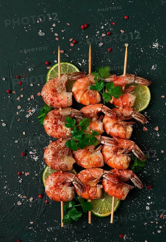 Shrimp kebab, with spices, lime, on wooden skewers, top view, no people