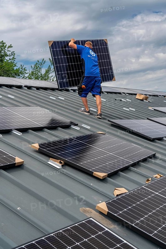 Installation of solar modules on the roof of a barn on a farm, over 240 photovoltaic modules are installed on the roof, North Rhine-Westphalia, Germany, Europe