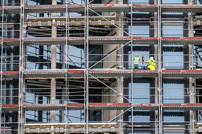 Large construction site, construction of a residential building with many flats, scaffolding, windows are installed, being sealed, grouted, Frankfurt am Main, Hesse, Germany, Europe
