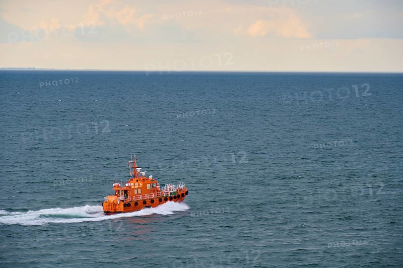 An orange pilot boat sailing on the open sea under a cloudy sky, Kiel, Schleswig-Holstein, North Sea, Germany, Europe