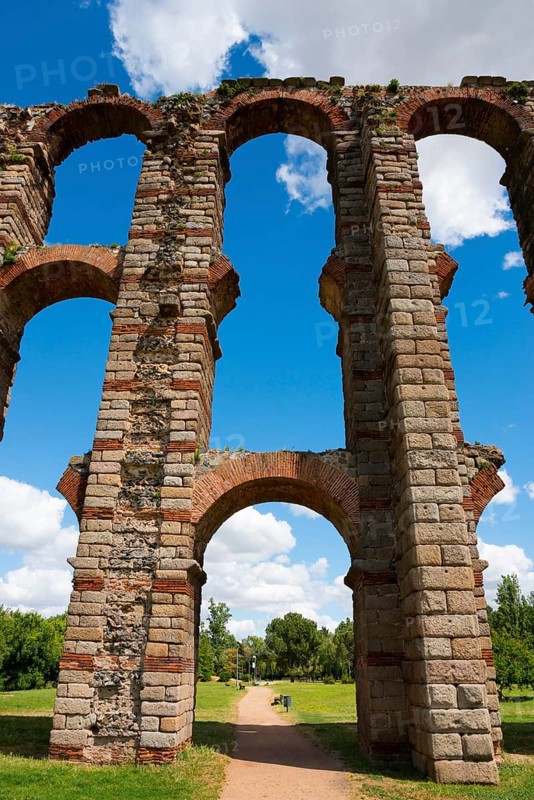 Überreste eines antiken Aquädukts mit hohen Bögen vor einem blauen Himmel und grüner Landschaft, Acueducto de los Milagros, Mérida, Merida, Badajoz, Extremadura, Spanien