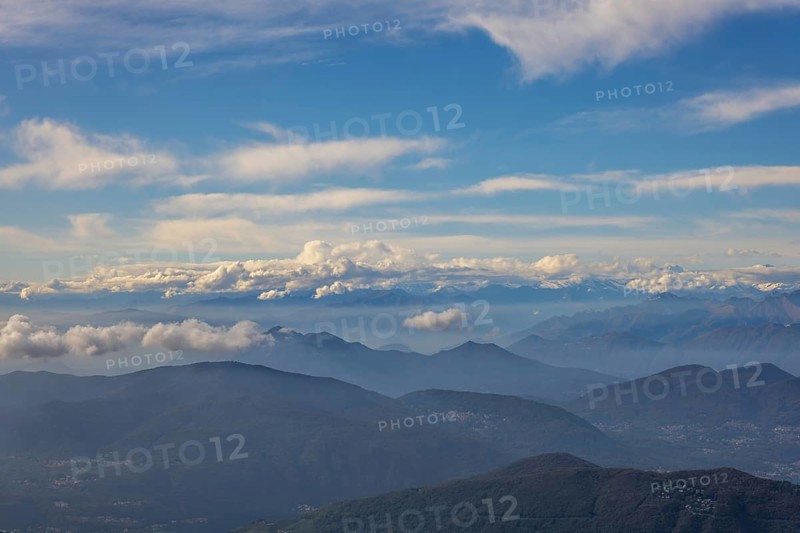 Aerial View over a Beautiful Mountainscape and And Snow Capped Mountain and with Floating Clouds in a Sunny Day in Ticino, Switzerland, Europe