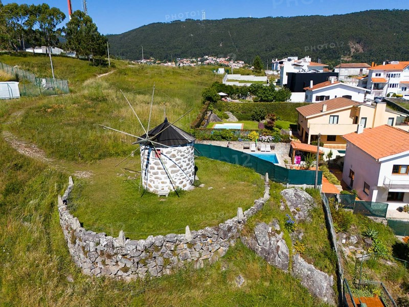 Windmill on a hill with surrounding houses and fences in a small village, aerial view, mill, Montedor, Viana do Castelo, Portugal, Europe