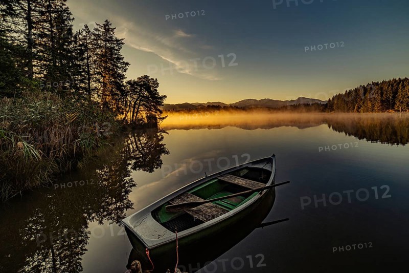 Boats in the autumnal Schmutter Weiher in the Allgäu near the municipalities of Halblech, Roßhaupten and Lechbruck in Ostallgäu in the foothills of the Alps