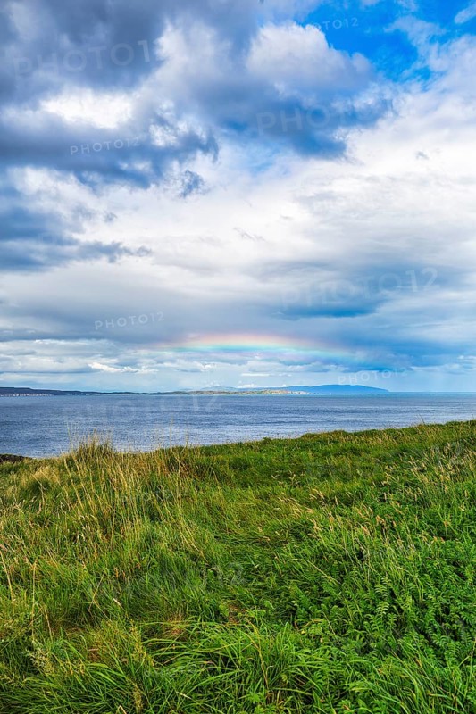 Rainbow over the sea, coastline between Ballycastle and Ballintoy, Carrick-a-Rede, Causeway Coastal Route, Antrim, Northern Ireland, Great Britain