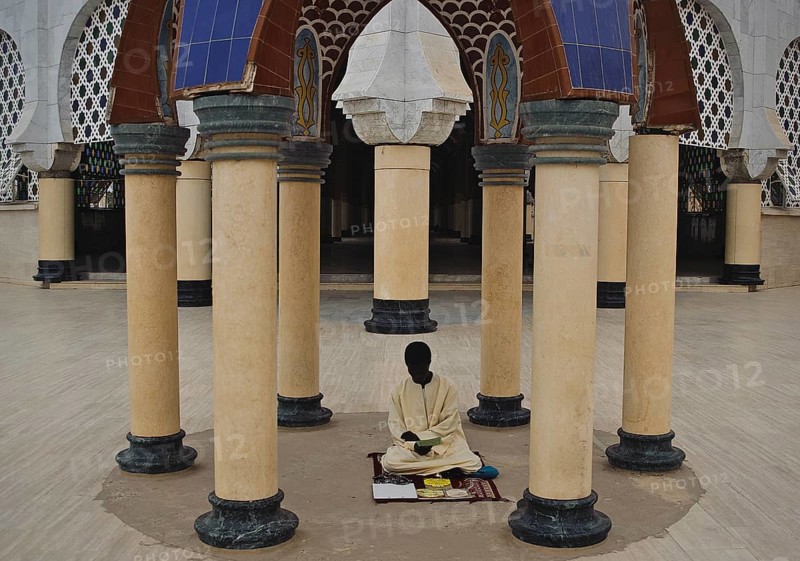 A muslim religious student is reading a book in the Great Mosque at Touba Senegal