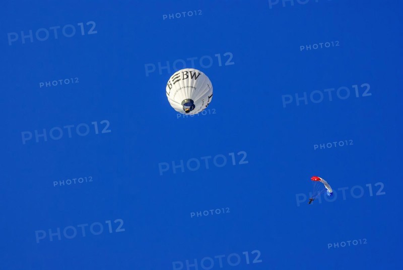 Landesbank BW hot air balloon and parachutist with open parachute in the air, as part of the aviation festival on the Rossfeld in Metzingen-Glems, Metzingen, Baden-Württemberg, Germany, 11 September 2010, for editorial use only, Europe
