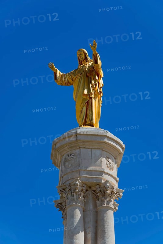 Golden statue of Jesus on a high column in front of a blue sky, Christ statue, Santuario de Fatima, place of pilgrimage, Fatima, Fátima, Ourem, Santarem, Portugal, Europe