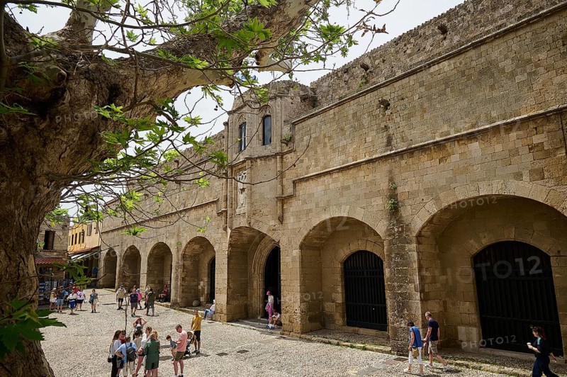Building of the Archaeological Museum, people walking in front of a large historical building on a stony square, shaded by a tree while the sun is shining, Rhodes Old Town, Rhodes Town, Rhodes, Dodecanese, Greek Islands, Greece, Europe